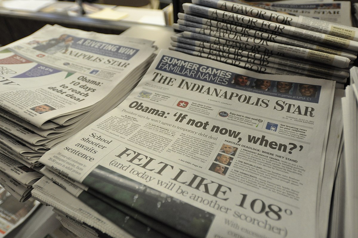 تعدادی روزنامه مرتب و چیده شده جلوی قفسه